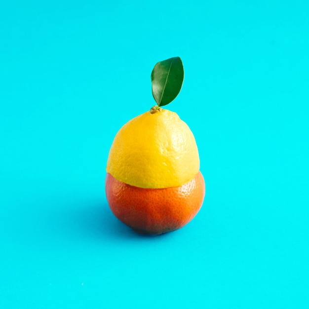 Eine Kombination aus Zitrone und Tangarine mit grünem Blatt auf blauem Hintergrund