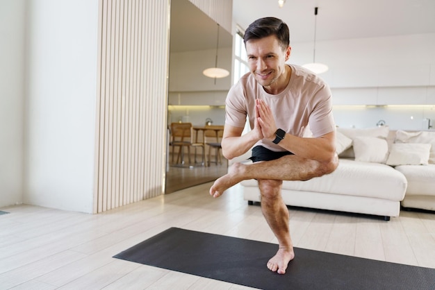 Eine konzentrierte Person behält das Gleichgewicht in einer Yoga-Baum-Pose, die Körper und Geist in Harmonie bringt