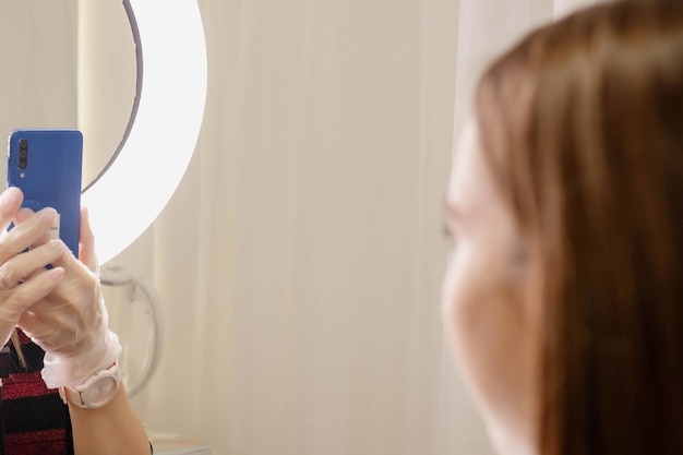 Eine Kosmetikerin fotografiert die Korrektur der Augenbrauen Kosmetikerin bei der Arbeit