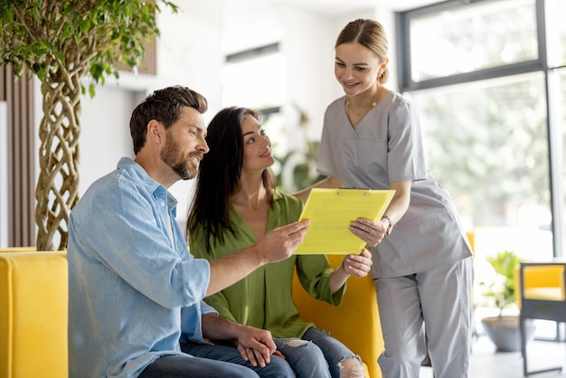 Eine Krankenschwester kommuniziert mit Patienten im Wartezimmer einer Klinik