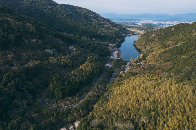 Eine kurvenreiche Straße durch die Berge mit einem See im Hintergrund.