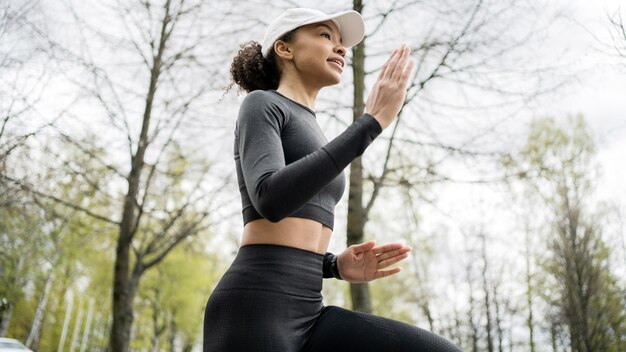 Eine Läuferin betreibt Fitness-Lauf in bequemer Sportbekleidung, einer intelligenten Uhr und einem Tracker an der Hand