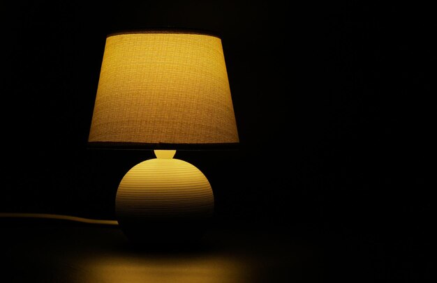 Eine Lampe in einem dunklen Raum mit einem gelben Lampenschirm.