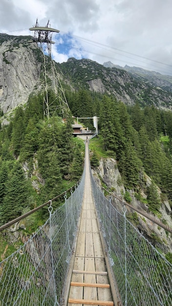 Foto eine lange hängebrücke mit einem berg im hintergrund bei guttannen siwtzerland