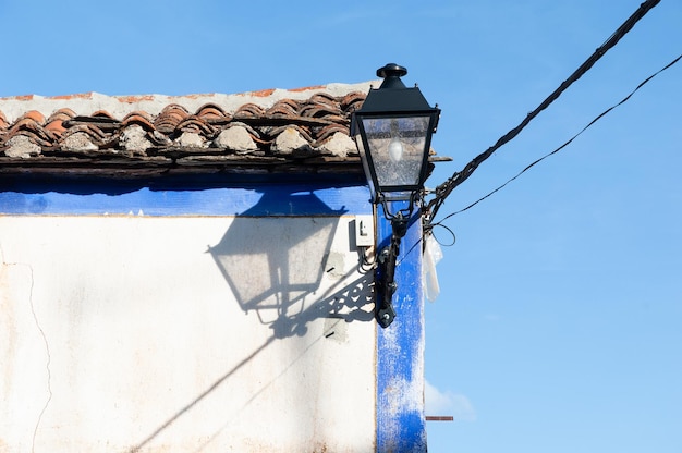 Eine Laterne mit Glühbirne beleuchtet die Ecke eines Hauses in einem spanischen Dorf