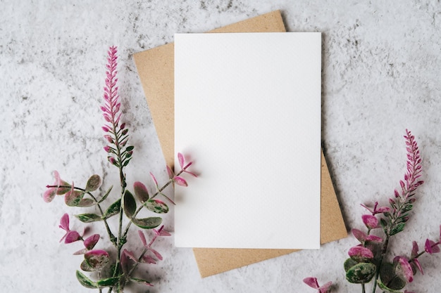 Eine leere Karte mit Umschlag und Blume auf weißem Hintergrund