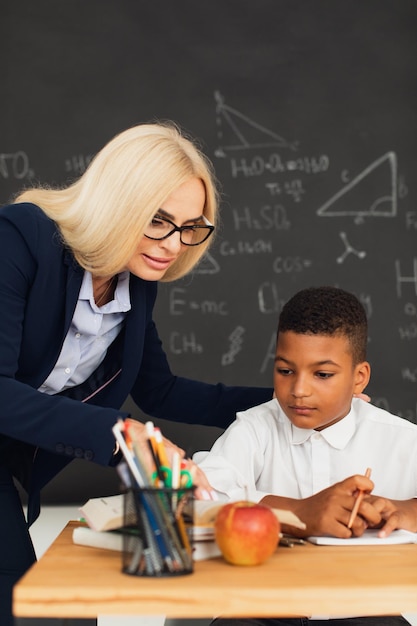 Eine Lehrerin hilft einem Schüler, ein Problem zu lösen Internationales Team Back to school