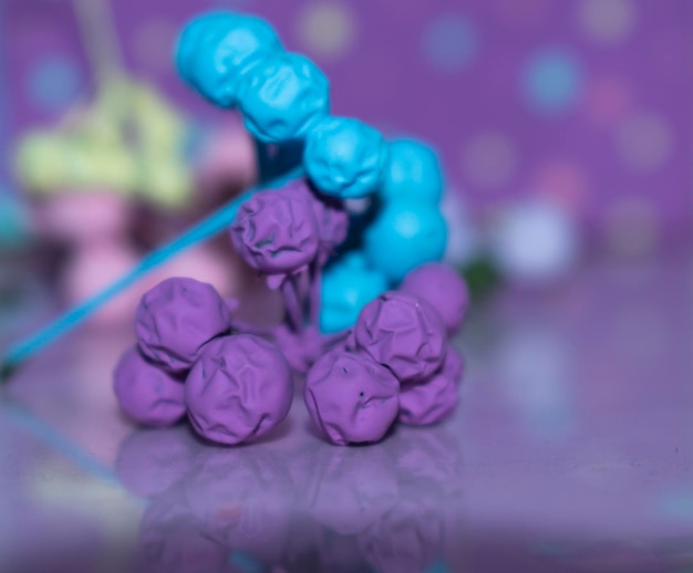 Eine lila-blaue Bonbonstange liegt zusammen mit anderen Bonbons auf einem Tisch.