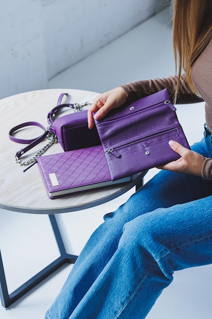 Eine lila Ledertasche in der Hand eines Mädchens Frau mit Luxus-Tasche