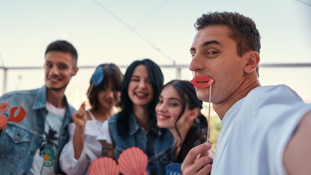 Eine lustige gruppe glücklicher freunde, die ein selfie machen, während sie auf dem dach feiern?