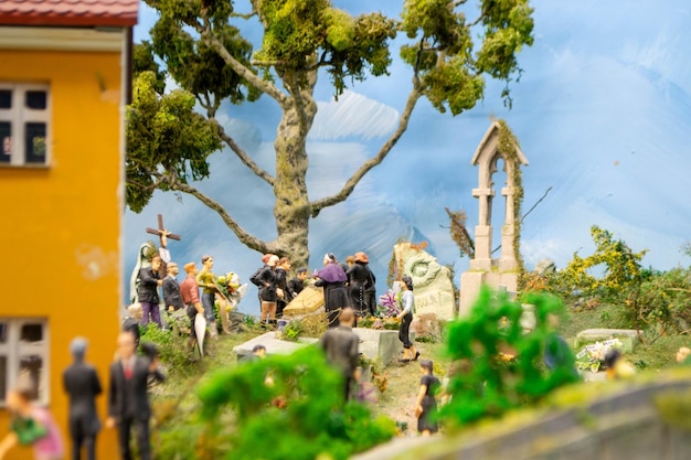 Eine Miniaturszene einer Dorfszene mit einer Kirche und einem Baum im Vordergrund.