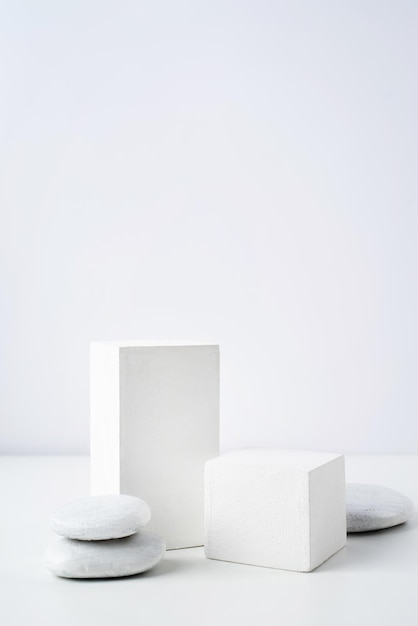 Eine minimalistische Szene eines Gipspodiums mit Steinen auf weißem Hintergrund für Naturkosmetik
