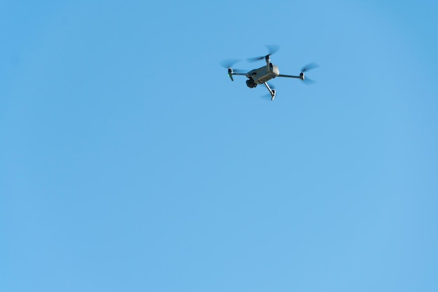 Eine moderne Drohne vor einem strahlend blauen Himmel Der Quadcopter schwebte bewegungslos am Himmel Der Einsatz von Flugzeugen zur Aufklärung und Feuerkorrektur