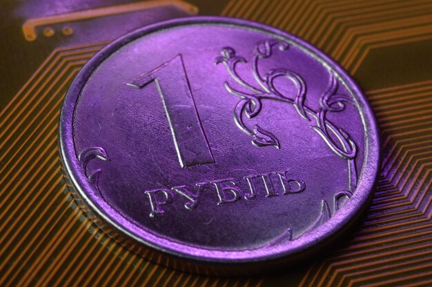 Eine Münze mit einem Nennwert von 1 Rubel liegt auf einer Mikroschaltung in der Nähe Übersetzung der Inschrift auf der Münze „1 Rubel“ Das Konzept der digitalen Wirtschaft in der Russischen Föderation
