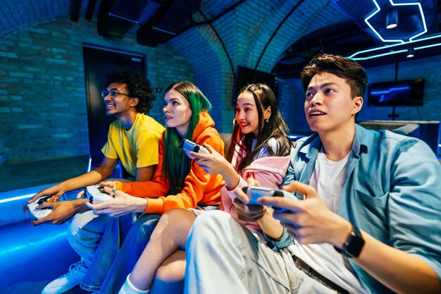 Eine multiethnische Gruppe junger Freunde spielt zu Hause Videospiele