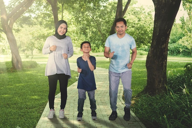 Eine muslimische Familie joggt zusammen im Park