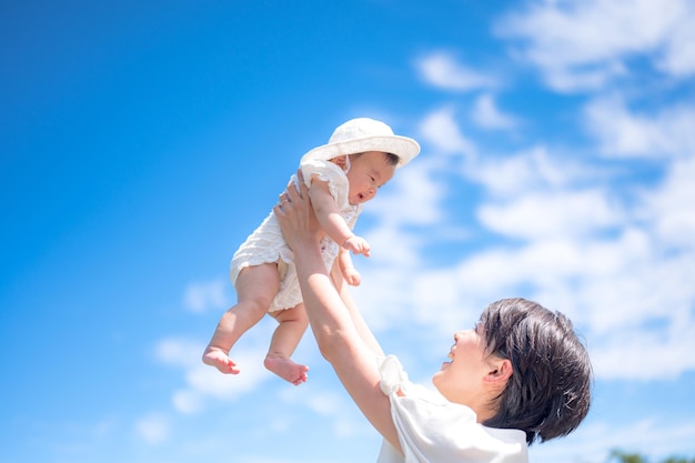 Eine Mutter hält ihr Baby in den Himmel