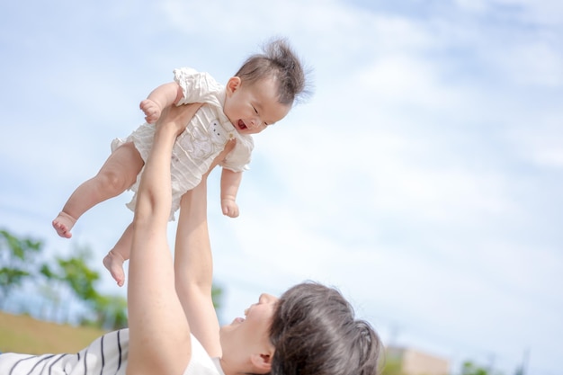 Eine Mutter hält ihr Baby in die Luft.