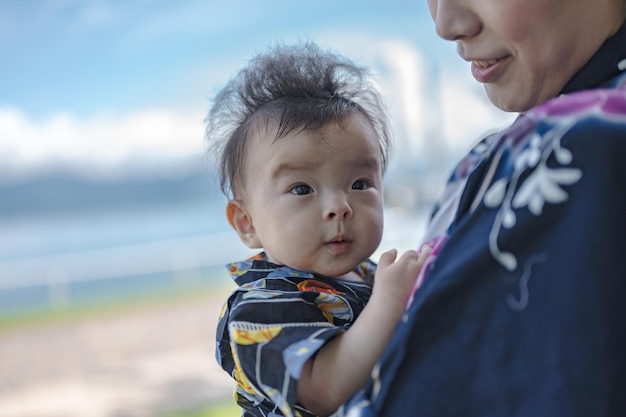 Eine Mutter hält ihr Baby in einem blauen Hemd.