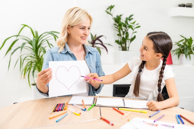 Eine Mutter hilft ihrer Tochter bei den Hausaufgaben.