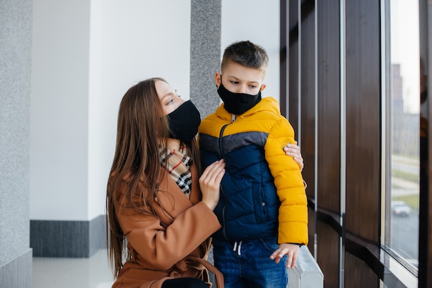 Eine Mutter mit ihrem Kind steht während der Quarantäne in einer Maske. Pandemie, Coronavirus