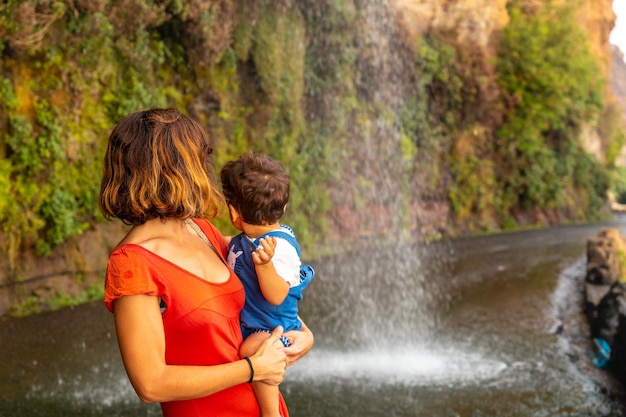 Eine Mutter mit ihrem Sohn im Urlaub am Anjos Wasserfall Madeira hat Spaß