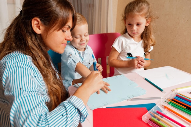 Eine Mutter mit Kind sitzt am Tisch und macht Hausaufgaben. Das Kind lernt zu Hause. Häuslicher Unterricht.