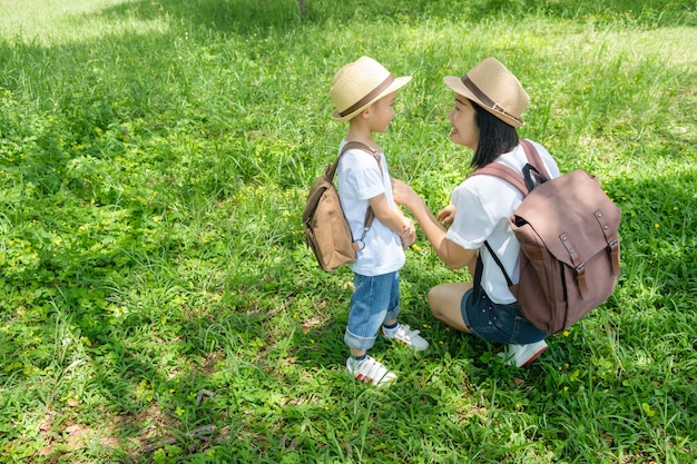 Eine Mutter und ein Sohn, die draußen in den Grasfeldern spielen