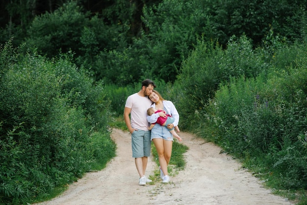 Eine Mutter und ein Vater mit einem kleinen Sohn, der im Wald spazieren geht