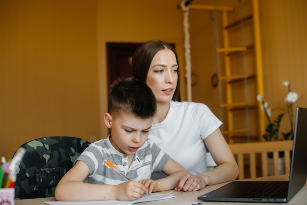 Eine Mutter und ihr Kind lernen zu Hause vor dem Computer im Fernunterricht. Bleib zu Hause, trainiere.