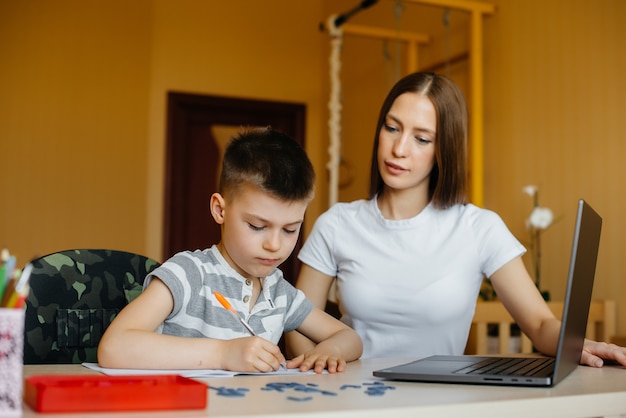 Eine Mutter und ihr Kind lernen zu Hause vor dem Computer im Fernunterricht. Bleib zu Hause, trainiere.