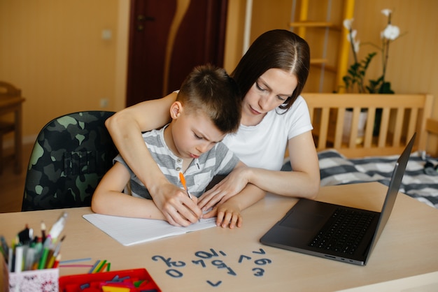 Eine Mutter und ihr Kind lernen zu Hause vor dem Computer im Fernunterricht. Bleib zu Hause, trainiere.