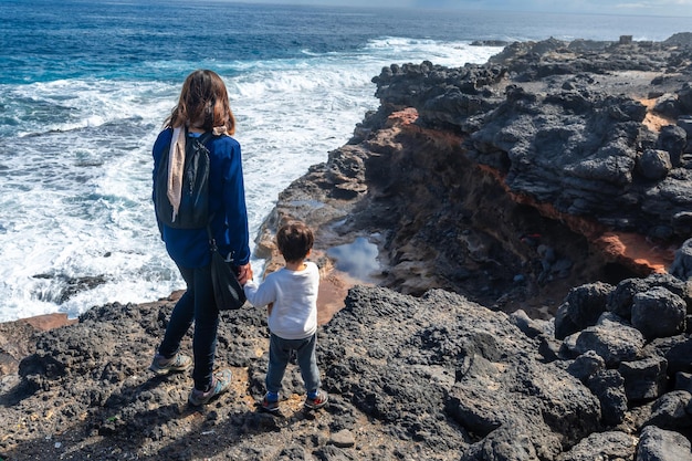 Eine Mutter und ihr Sohn schauen auf das Bufadero de La Garita Telde Gran Canaria Kanarische Inseln