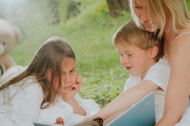 Eine Mutter und ihre Kinder lesen gemeinsam ein Buch.