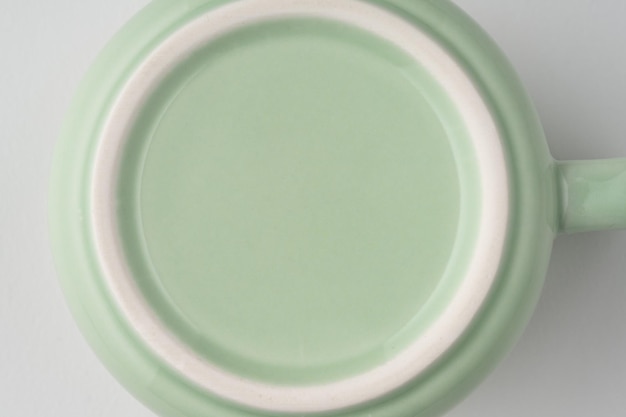 Eine Nahaufnahme der Unterseite einer pastellgrünen Teetasse