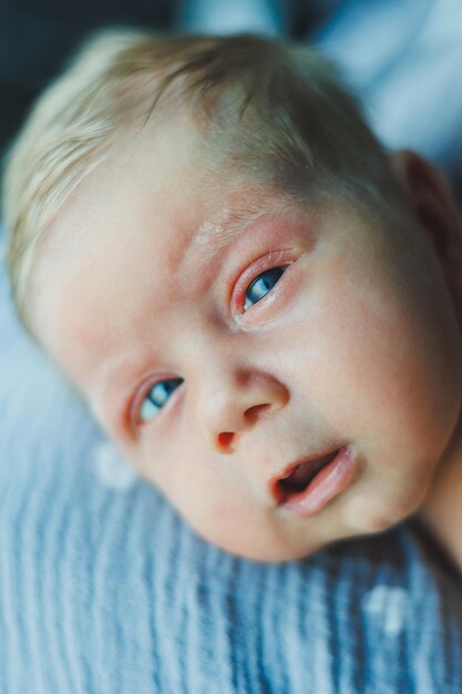 Eine Nahaufnahme des Gesichts eines Neugeborenen Ein Neugeborenes schaut in die Kamera Offene Augen eines Neugeborenen