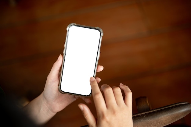 Foto eine nahaufnahme einer frau, die ihr smartphone im innenraum benutzt ein smartphone-mockup auf weißbildschirm