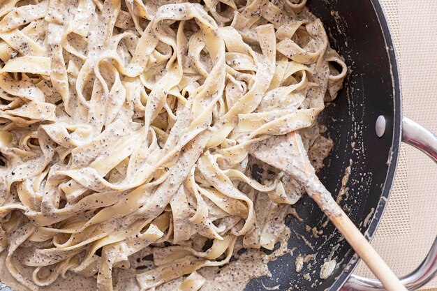 Eine Nahaufnahme einer schmutzigen Pfanne mit Fettuccine