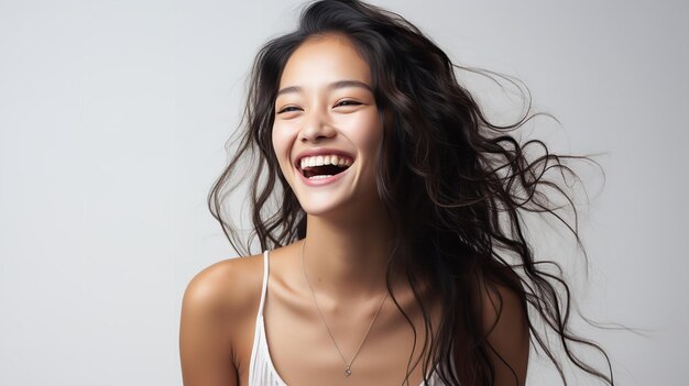 Foto eine nahaufnahme eines hübschen jungen asiatischen modells, das lächelt und ihre perfekten zähne auf weißem hintergrund zeigt