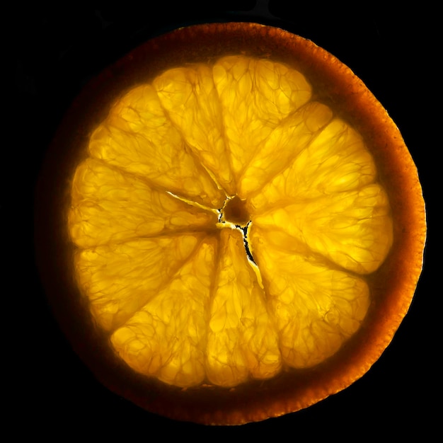 Eine Nahaufnahme Fotografie einer Orangenscheibe im Gegenlicht Orangenscheibe auf schwarzem backgroung