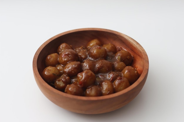 eine Nahaufnahme von Cilok aus Tapioca-Mehl und einer köstlichen Erdnusssauce, die in einer Holzschüssel auf weißem Hintergrund serviert wird