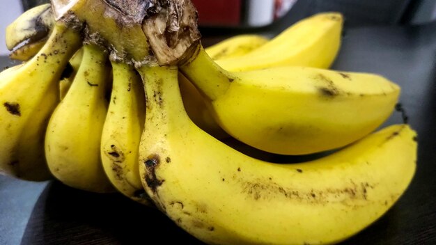 Eine Nahaufnahme von reifen gelben Bananen auf einem Holztisch