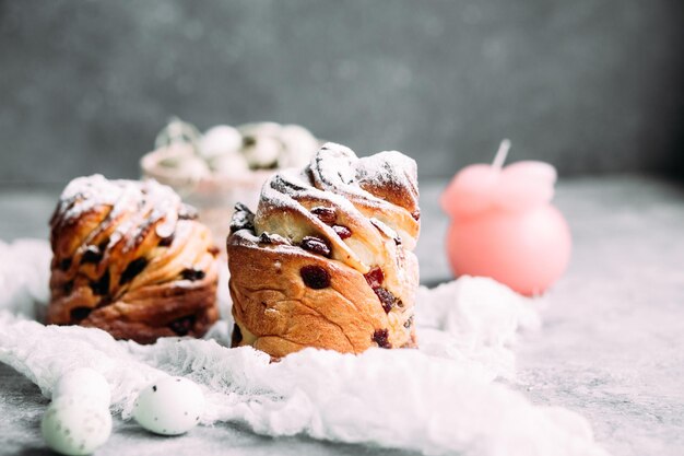 Eine Nahaufnahme von zwei Scones mit einer Kerze im Hintergrund