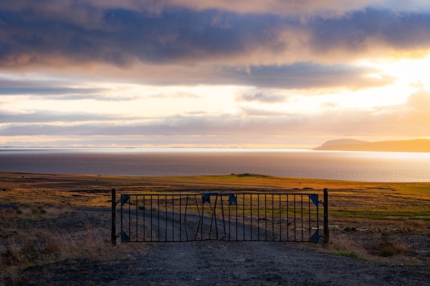 Eine neblige Landschaft mit Tor und dramatischer Wolkenlandschaft während des Sonnenuntergangs