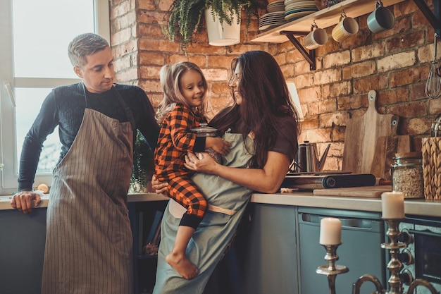 Eine nette kleine Familie steht zusammen in der Küche und plant etwas zu kochen.