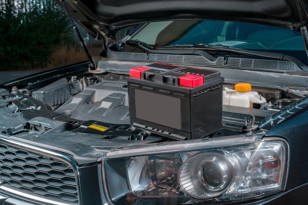 Foto eine neue batterie sitzt auf dem motor eines autos mit offener motorhaube