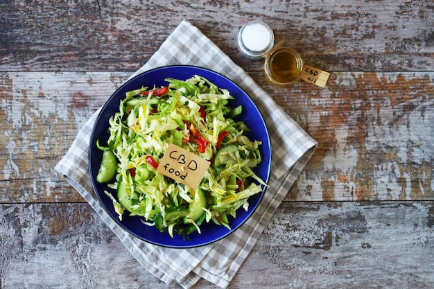 Eine Notiz mit den Worten cbd Essen in einem Teller mit Gemüsesalat.