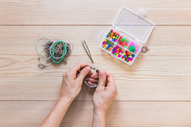 Eine obenliegende Ansicht der Hand handgemachten Schmuck über dem Schreibtisch machend