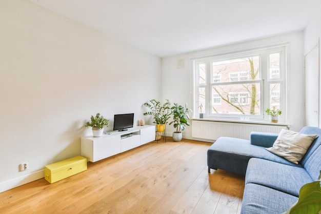 Eine offene Wohnung mit einem Wohnzimmer und einem großen blauen Sofa in einem modernen Haus