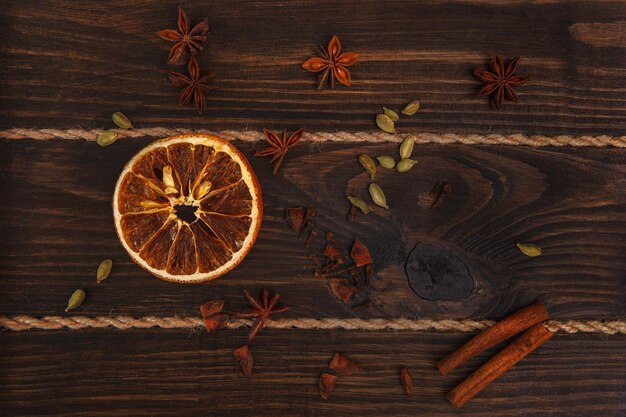 Eine Orange mit Zimt und Sternanis auf einem hölzernen Hintergrund